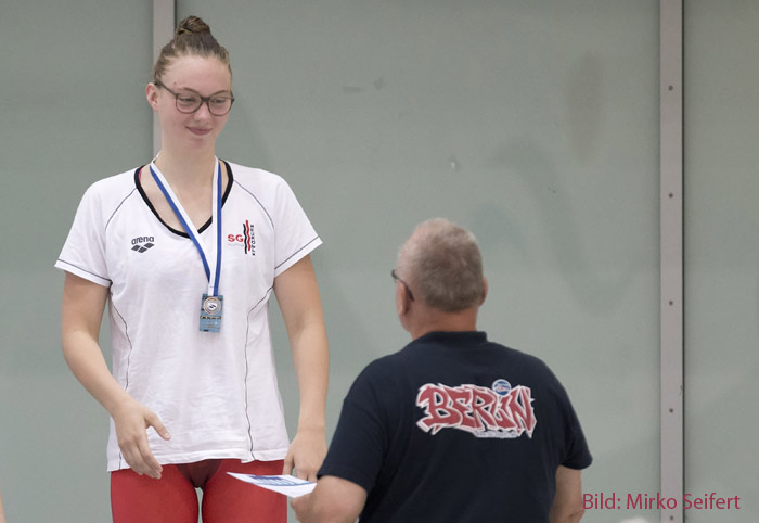 Josephine Tesch erhält ihre 400. Medaille bei einem Schwimmwettkampf.